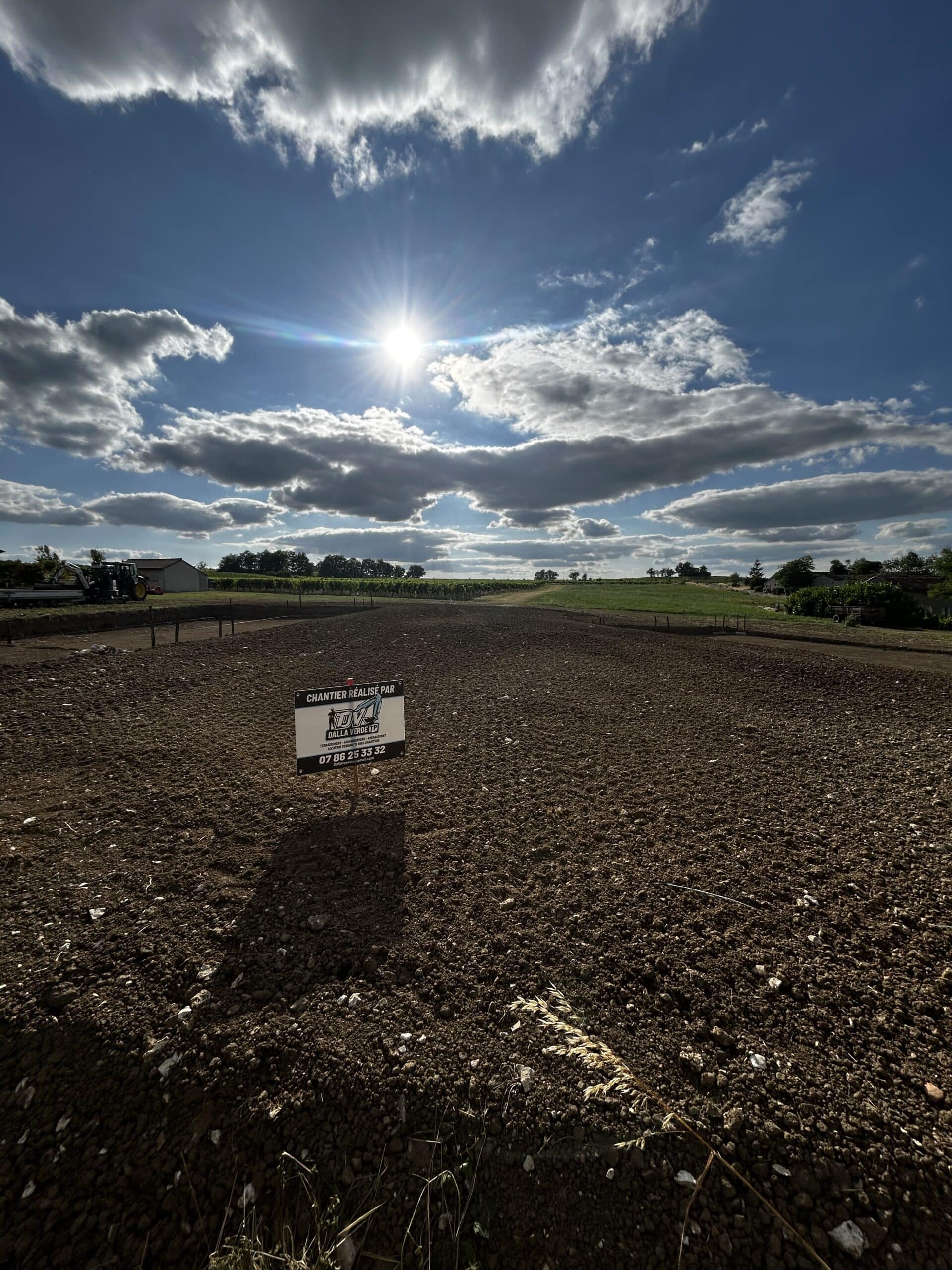 Excavation au Coucher du Soleil : Travaux Lourds et Lumière Dorée Godet d'excavatrice jaune déversant de la terre et des roches au coucher du soleil dans une carrière, créant une forte lueur dorée.